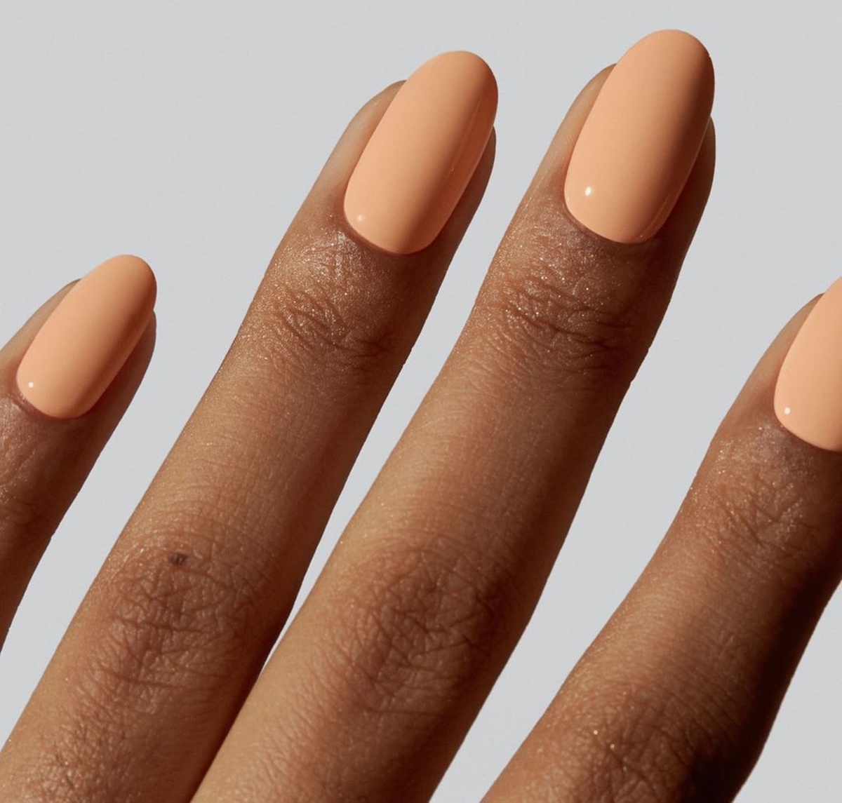 unhas com esmalte laranja clarinho