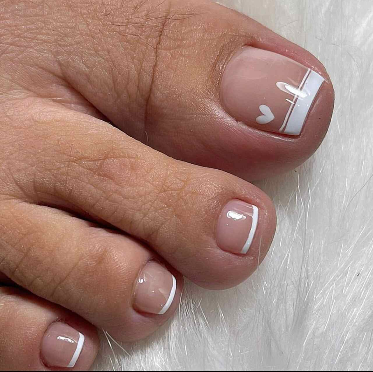 Unhas dos pés com francesinha larga e desenho de coração