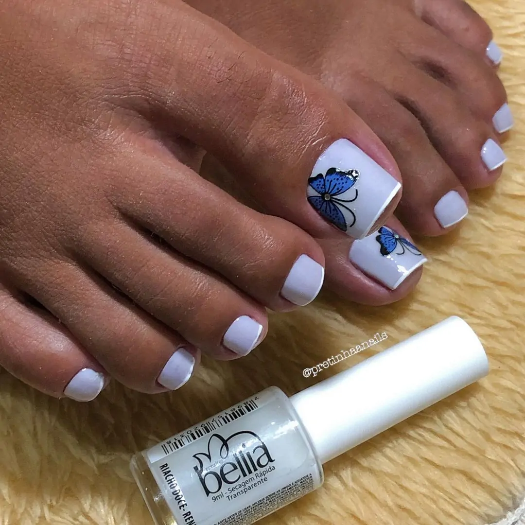 Unhas dos pés com decoração de borboleta azul