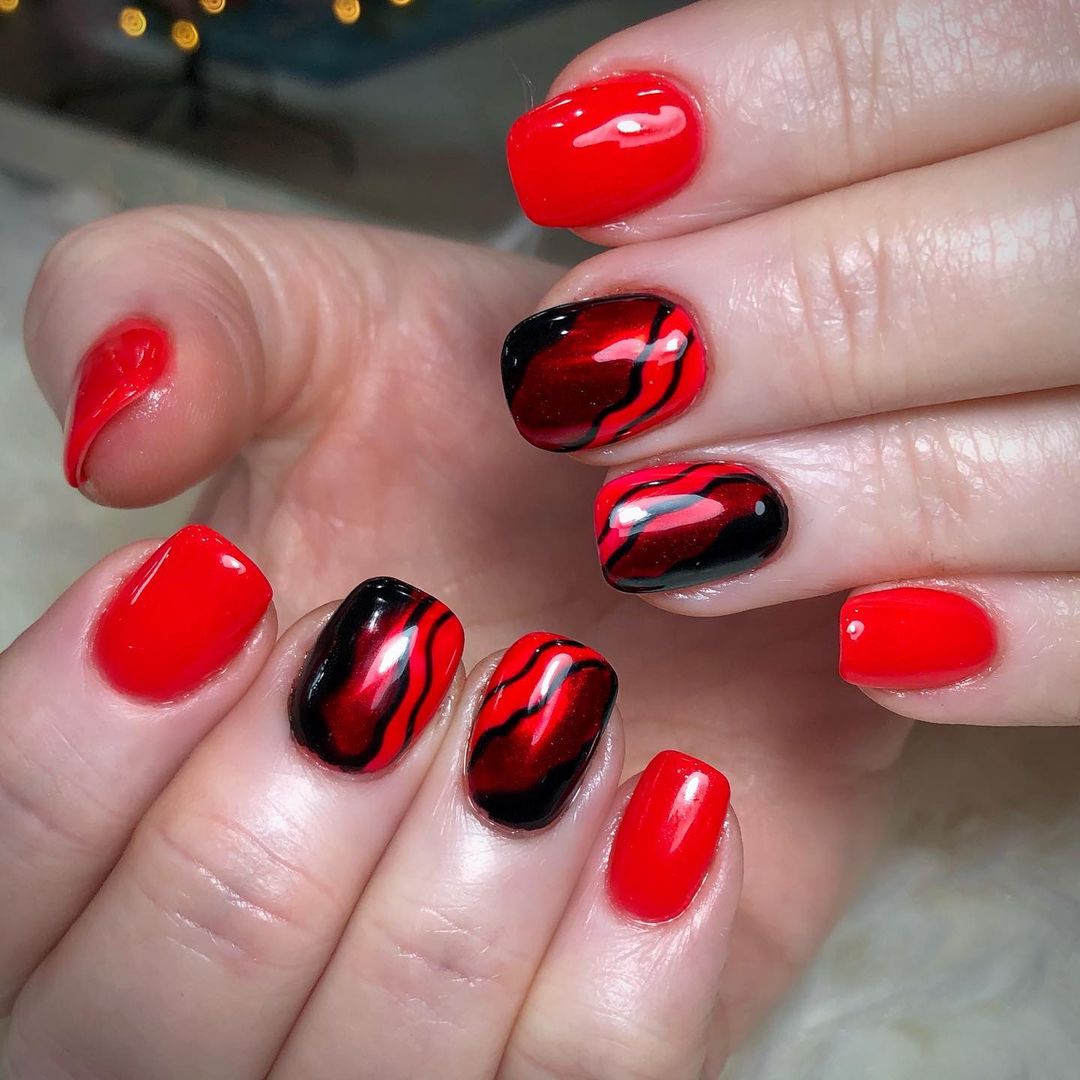 Unhas com efeito marmorizado em vermelho e preto